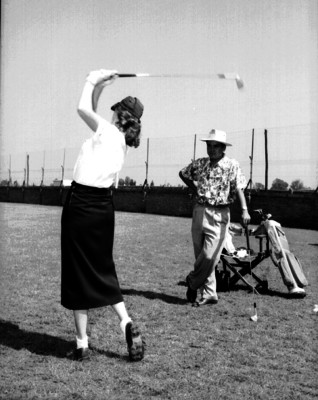 Juan Neri observa a una mujer lanzar la bola durante un entrenamiento