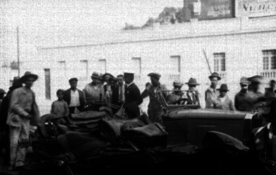 Espectadores observando restos de un automóvil accidentado