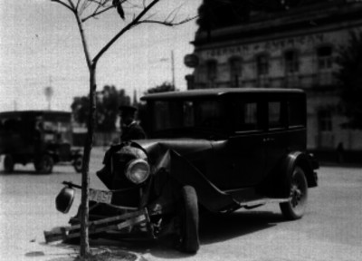 Agente de transito observando un auto chocado
