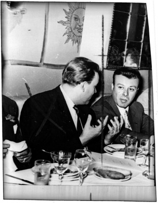 Hesiquio Aguilar, periodista, conversa con un hombre durante un banquete