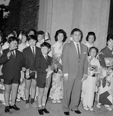 Grupo coral japonés con banderas Mexicanas durante la recepción de bienvenida a Adolfo López Mateos