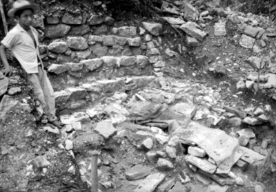 Niño a un costado de escaleras en excavación