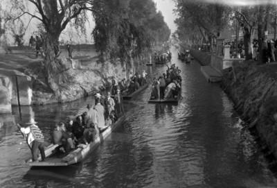 Gente abordo de trajineras en el Canal de la Viga en Xochimilco