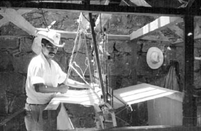 Artesano realiza una prenda en un telar mecánico