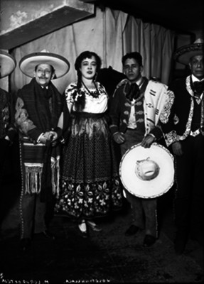 Josefina Llaca, acompañada por Miguel Lerdo de Tejada, y otros cantantes, vestidos con atuendos folclóricos