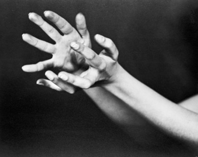 Manos crispadas de bailarina, fondo oscuro