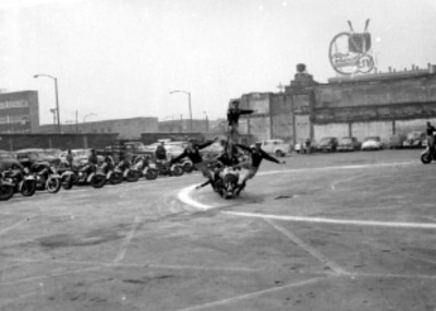 Acróbatas del escuadron de motociclismo, dando un espectaculo en un estacionamiento