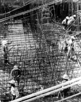 Trabajadores levantan estructura con varilla, durante la construcción del metro