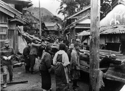 Pescadores japoneses empujan una embarcación por calle de un poblado