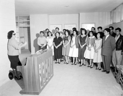 Maestros, mujeres y hombres durante clase de piano
