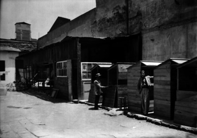 Hombres entre calle recién pavimentada y puestos comerciales